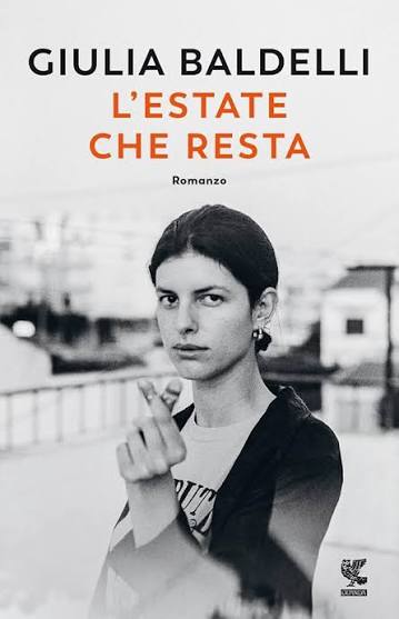 • Copertina del libro d'esordio "L'estate che resta" di Giulia Baldelli, edito da Guanda. Ritratto fotografico in bianco e nero di una giovane donna malinconica con una sigaretta tra le dita.